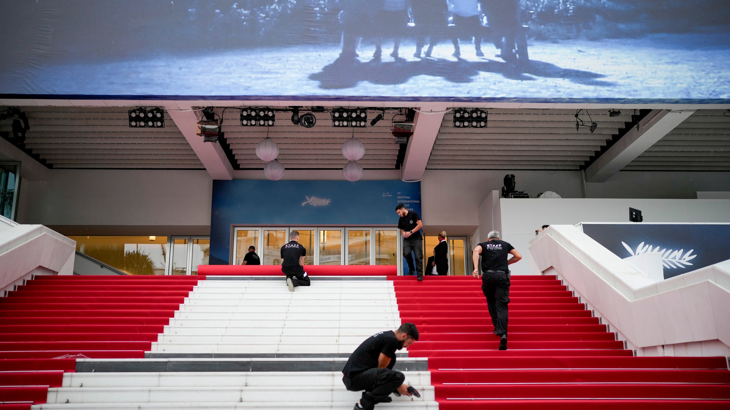 Festival workers lay the red carpet at the Palais des Festivals on opening day of the 77th international film festival, Cannes, southern France, Tuesday, May 14, 2024. The Cannes film festival runs from May 14 until May 25, 2024. (Photo by Andreea Alexandru/Invision/AP)