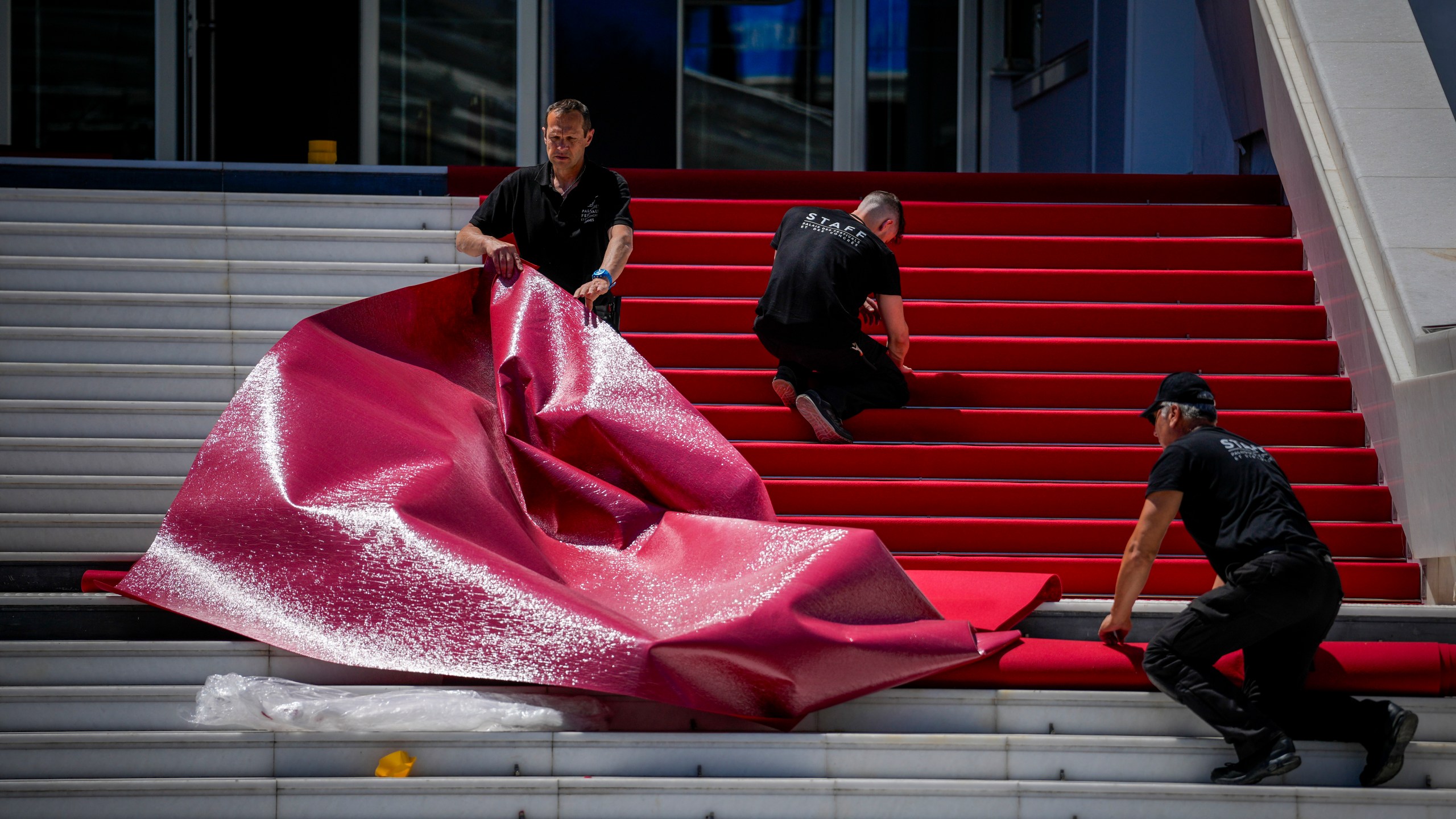Festival workers prepare the red carpet during preparations for the 77th international film festival, Cannes, southern France, Monday, May 13, 2024. The Cannes film festival runs from May 14 until May 25, 2024. (AP Photo/Andreea Alexandru)