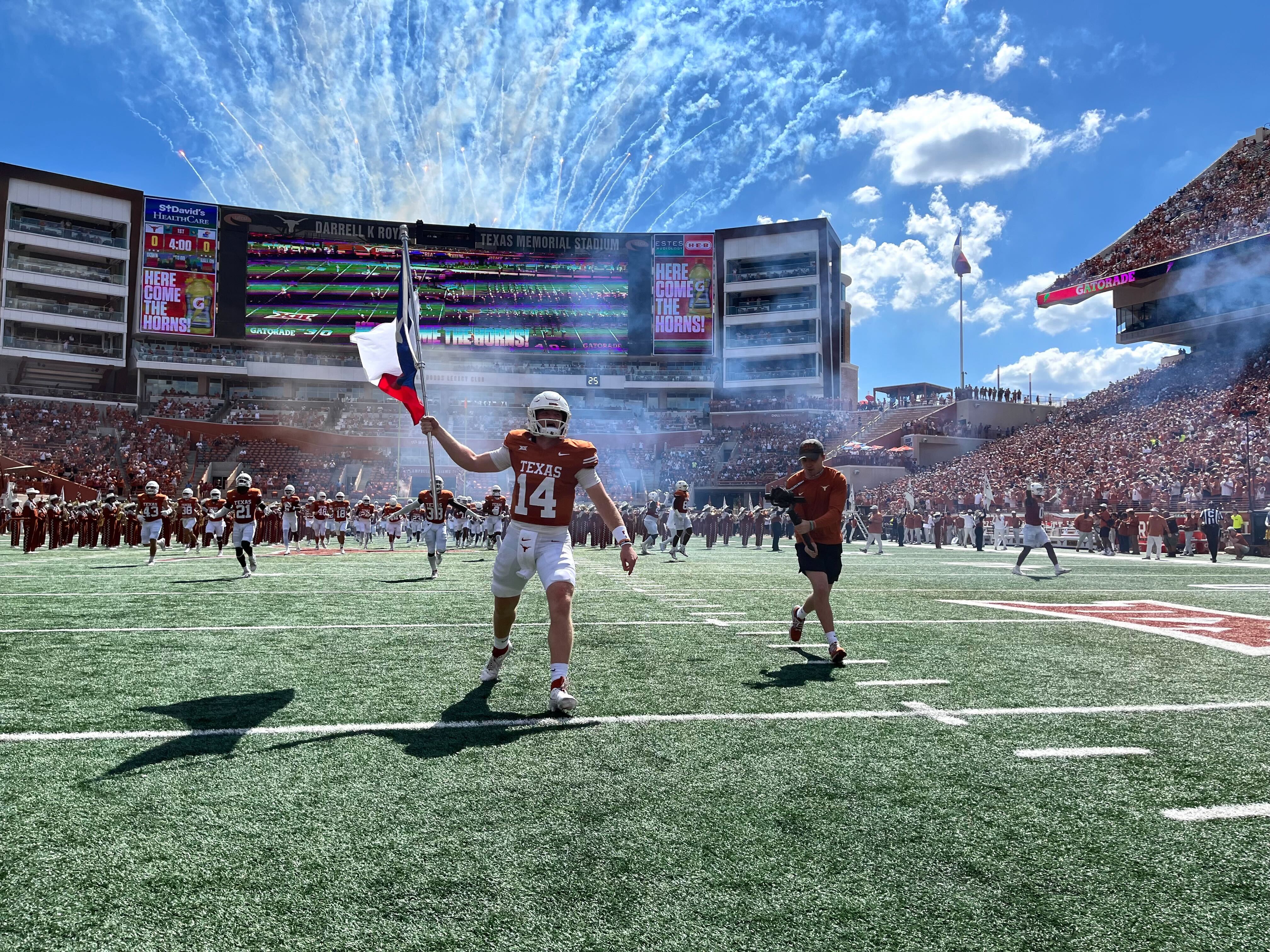 Texas reserve QB Charles Wright runs onto the field with the Texas flag before the Longhorns took on Kansas on Sept. 30 at DKR-Texas Memorial Stadium. (KXAN photo/Blake Devine)