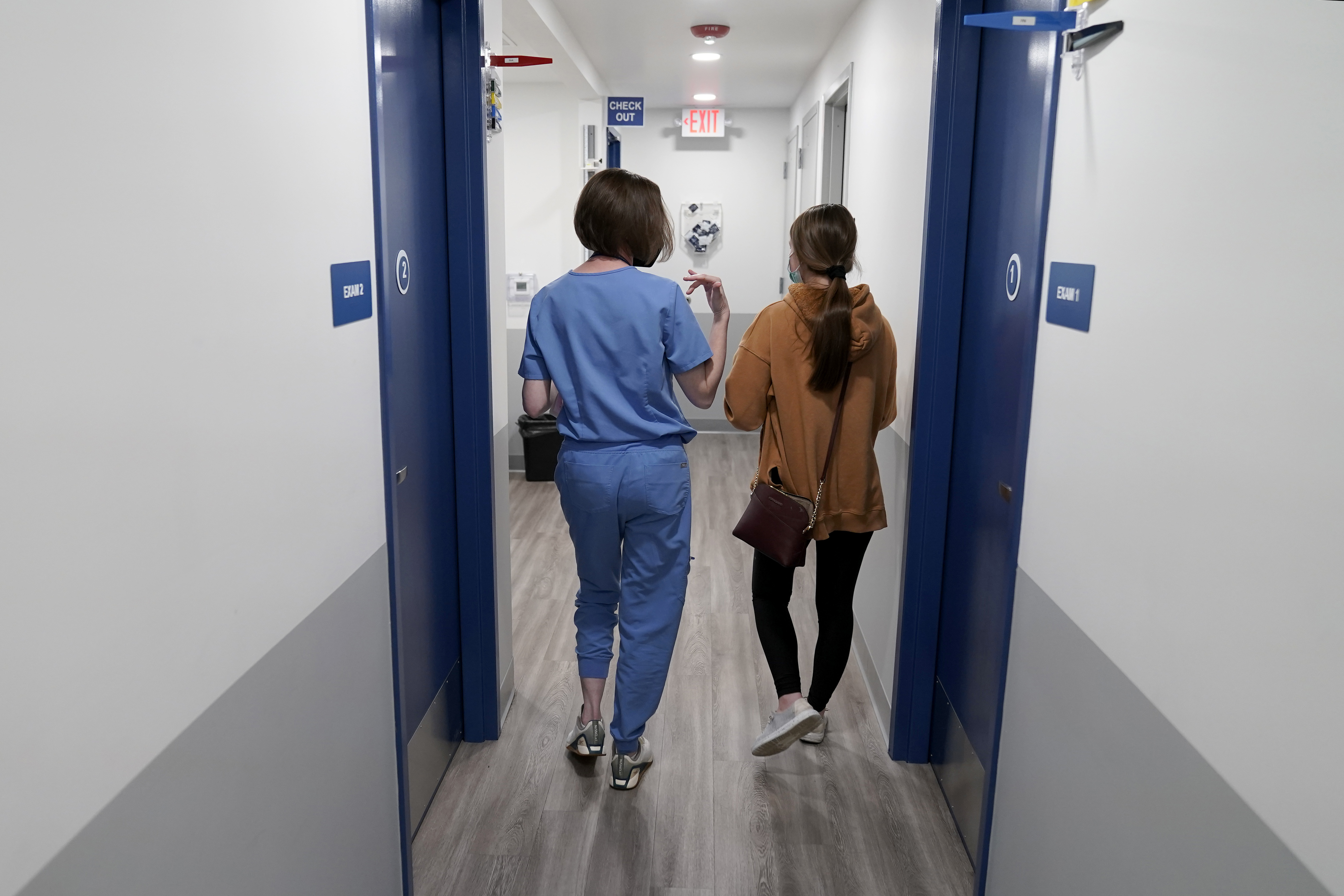 Dr. Elizabeth Brett Daily, left, walks with a patient after providing a medical abortion at a Planned Parenthood clinic Wednesday, Oct. 12, 2022, in Kansas City, Kan. (AP Photo/Charlie Riedel)