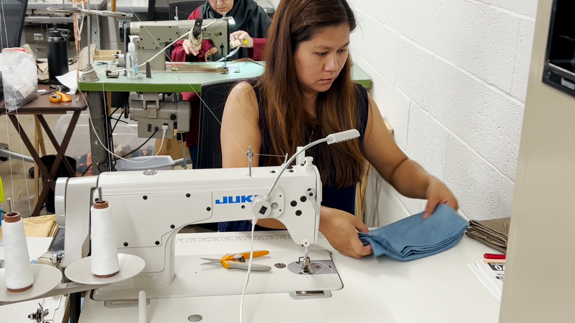 Maria Vung, manager at Multicultural Refugee Coalition who immigrated from Myanmar, sews a bag. (KXAN Photo/Sam Stark)